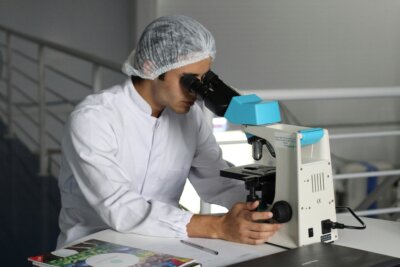 Zdravstveni djelatnik gleda kroz mikroskop