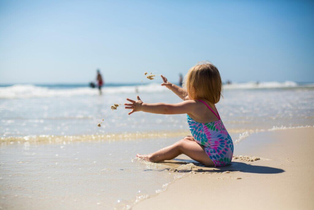 Dijete u kupaćem kostimu u pijesku na plaži