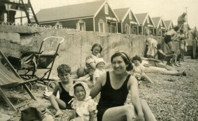 Crno-bijela fotografija žene s djecom na plaži